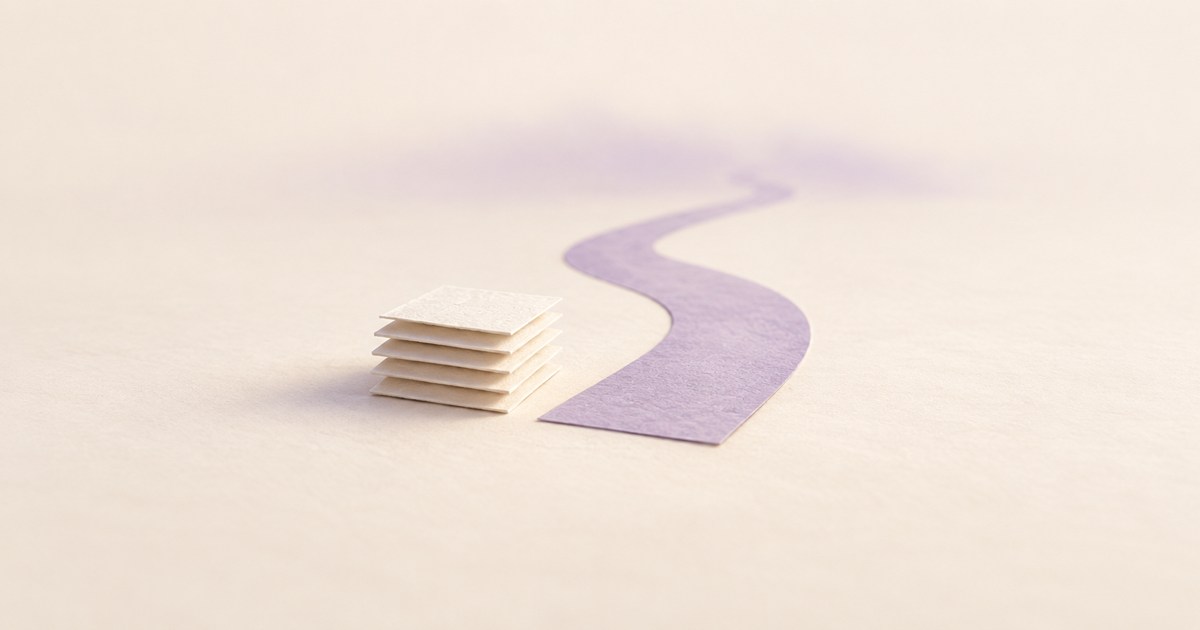 重ねたアイボリー色の時間の記録の先へ、淡い背景に伸びる紫の紙の道