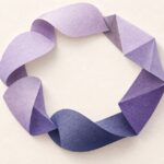 形を少しずつ変えながら輪につながる紙片の抽象彫刻