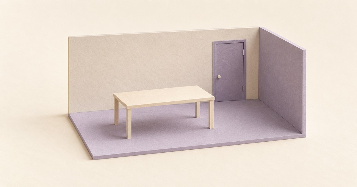 閉じた扉のある無人の部屋に机が一台置かれた紙模型