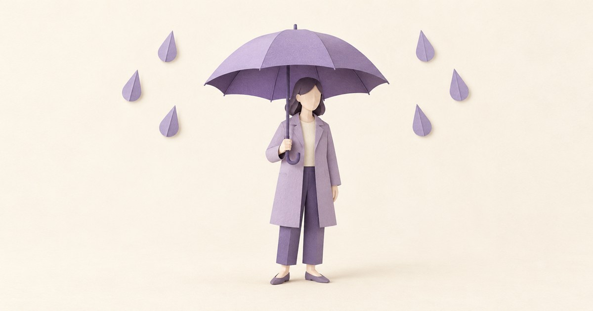 開いた傘の下に立つ紙人形と、傘の外側に落ちる雨粒の紙模型